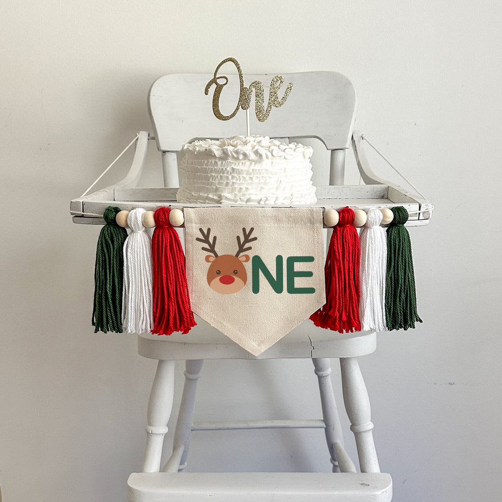 This is a 5x7 inch canvas flag with a cute reindeer head followed by the letters NE in green to spell out ONE. On each side there is a red, white and dark green tassel, each separated by a wooden bead for a total of 6 tassels and 6 beads.