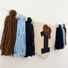 A banner with tassels hanging on a wall, featuring a large number 1 on it.