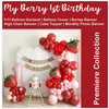 The image is a birthday party setup with a large balloon arch, a cake, and a high chair. The backdrop is decorated with a banner that reads "My Berry 1st Birthday".