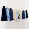 A banner with tassels and a blue and white checkered number 1, along with blue and white tassels, is displayed on a white wall.