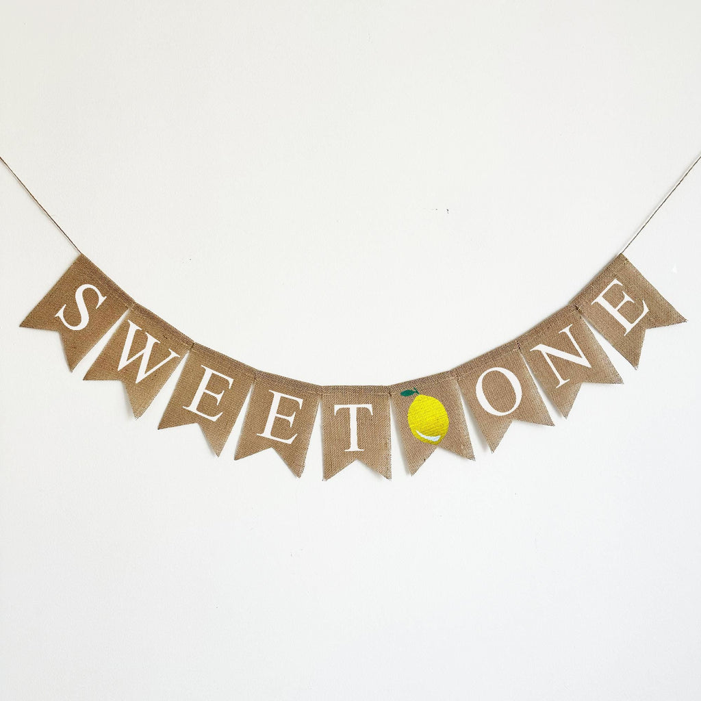 A banner with the word "SWEET TO" written on it, with a small yellow lemon graphic on the right side.