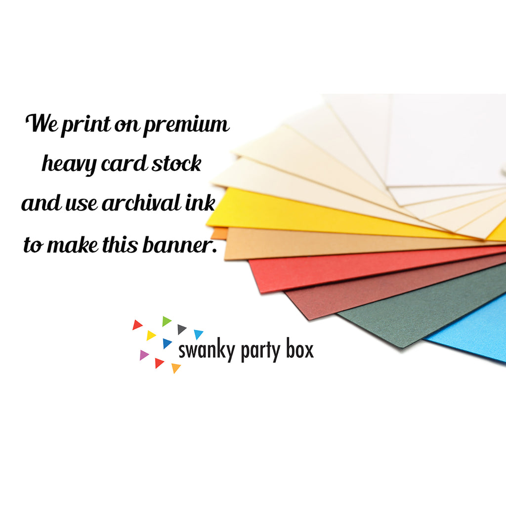 a variety of colorful paper sheets arranged in a fan-like pattern, with a text overlay that reads "We print on premium heavy card stock and use archival ink to make this banner."