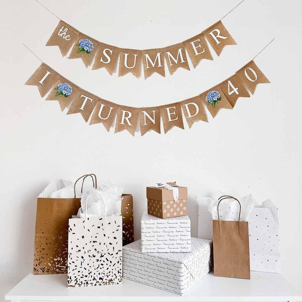 a festive display with a banner that reads "The SUMMER I TURNED 40", surrounded by gift bags and boxes.