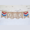 A banner with the word "ONE" written on it, made of burlap and decorated with patriotic colors.