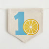 A banner with the number 1 and a lemon slice graphic printed on it.