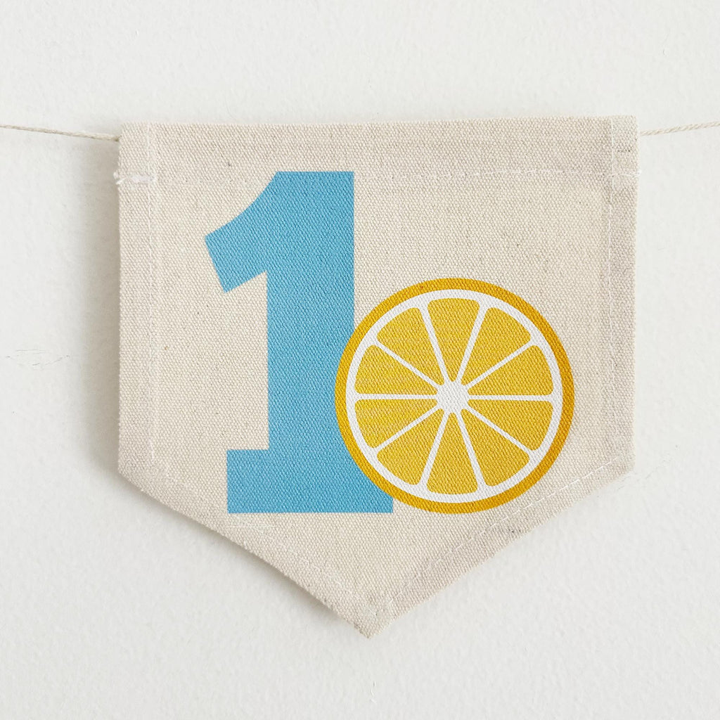A banner with the number 1 and a lemon slice graphic printed on it.