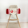 A canvas high chair banner featuring a red strawberry as the letter O followed by an "ne" spelling out the word "one" on it, along with tassels in pink and red.