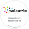 a logo for a company called "swanky party box" that specializes in custom event supplies. The logo includes a circular design with colorful triangles and the company's name in bold black text. Below the logo, there is text that reads "CUSTOM EVENT SUPPLIES HANDMADE IN THE USA". The website "www.swankypartybox.com" is also provided.