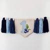 A banner with a blue and white checkered pattern, featuring the number 1 and blueberries, is hanging on a white wall.