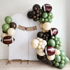 A balloon arch in the shape of a football, with various colored balloons, including green, brown, and white, arranged in a decorative manner.