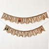 A banner with the words "ONE HAPPY CAMPPER" written on it, along with a small camp fire flag, a tree image banner and a s'mores marshmallow image.