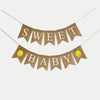 A banner with the words "Sweet Baby" written on it, with two yellow lemons attached to the bottom corners.