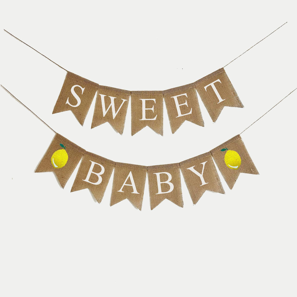 A banner with the words "Sweet Baby" written on it, with two yellow lemons attached to the bottom corners.