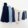 A banner with dark blue and light blue tassels hanging on a white wall, with a large number 1 displayed on the banner.