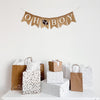 a burlap banner that says "OH BOY" with a football image between the words hanging above a table of gifts.