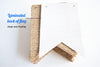 a stack of burlap fabric pieces with a white paper backing, which appears to be a homemade decoration or craft project.