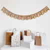 a festive display with a banner that reads "Sweet as Peach" and various gift bags and boxes arranged on a white surface.
