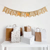 A burlap banner made of fishtail shaped flags with the words It&#39;s A Girl in white letters. There is an image of a peach between each word for a total of two peaches.