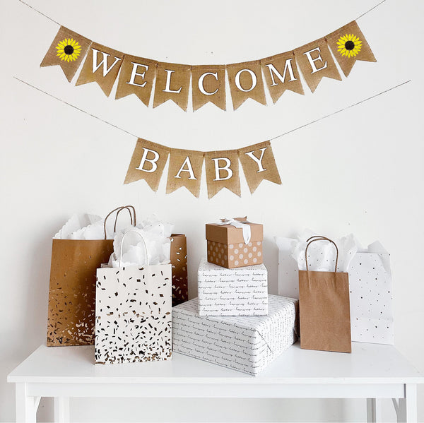 This burlap banner reads Welcome Baby with sunflower flags on either side of the word welcome. The sunflowers are hand painted in a vibrant yellow with a dark brown center making them the perfect addition to your celebration.