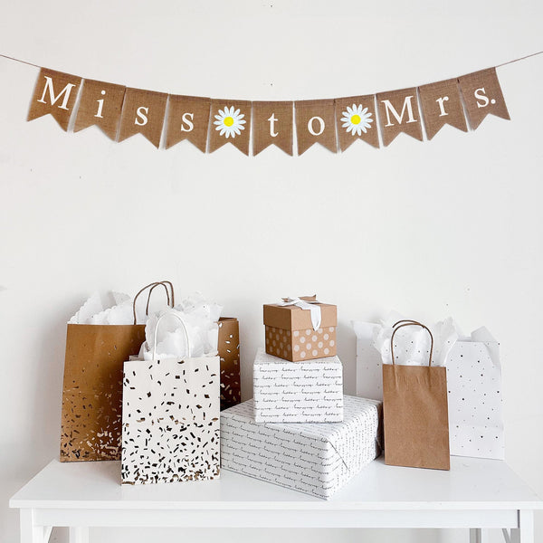 This Miss to Mrs. Burlap banner features white letters spelling out the wording with 2 write daisy hand stenciled flower between each word. It&#39;s the perfect addition to an engagement party or bridal shower decor.