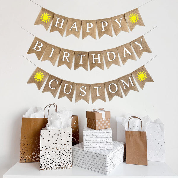 A three tiered burlap banner. The first line reads happy with two yellow sunshine images. The second line reads birthday. The third line reads custom- you can add the name of your choice here- and has two yellow sunshines.