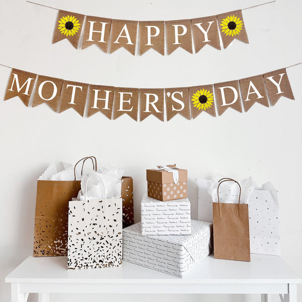 In white text, the banner in on two lines. The first line has a yellow sunflower flag followed by the word happy with another sunflower at the end. The second line reads mothers day with a sunflower in between each word.