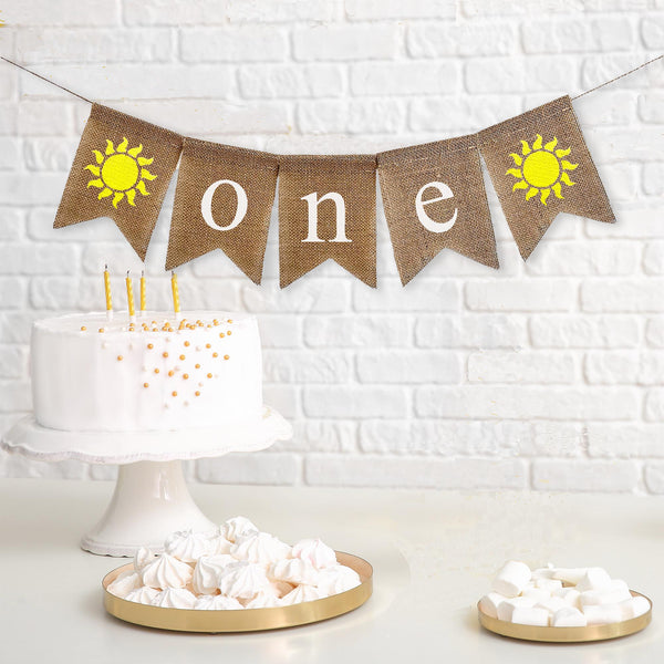 A burlap banner that reads one with yellow sunshine images on each end.