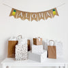 Tropical Aloha Burlap Banner. Aloha is written in white lettering on burlap flags with a hand stenciled pineapple on each end of the word. The pineapple is a bright yellow base with leafy green top.