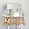 A burlap banner with a bumblebee with white wings as the O and a n and e flag.