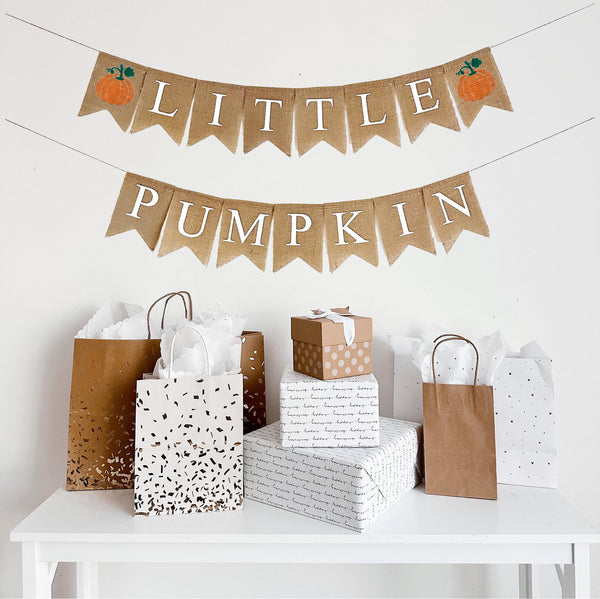 Burlap banner featuring two orange hand stenciled pumpkins with green stem. Letter flags spell out the words Little Pumpkin in white letters.