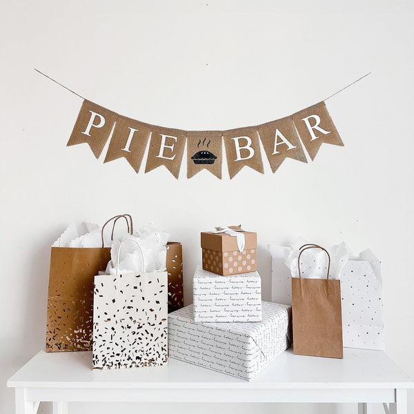 A burlap banner reading pie bar in white lettering with a pie image between the words.