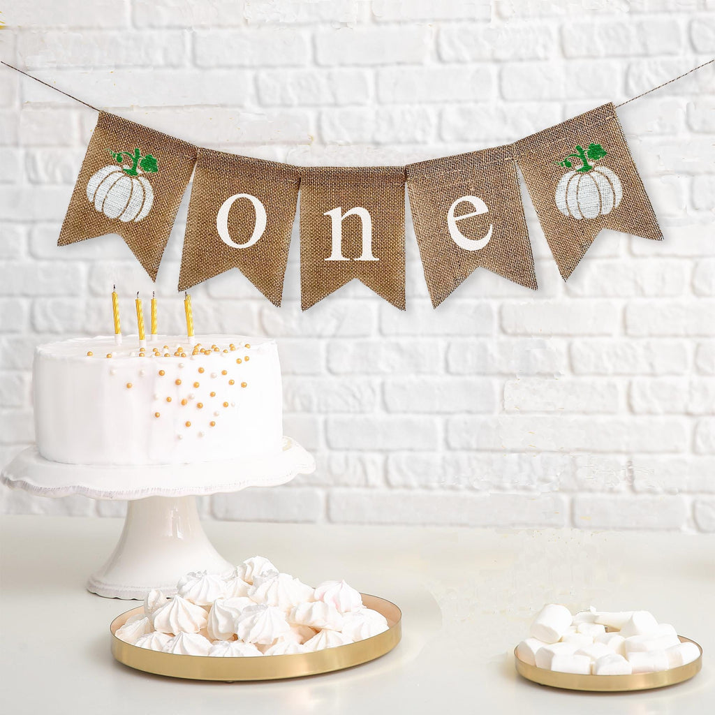 Celebrate one with this white pumpkin burlap banner. With unique white pumpkins on each end and the letters o n e spelled out in between in white lowercase letters, this banner is perfect for a fall first birthday celebration.