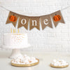Celebrate one with this rustic orange and brown pumpkin burlap banner. With rustic pumpkins on each end and the letters o n e spelled out in between in white lowercase letters, this banner is perfect for a fall first birthday celebration.