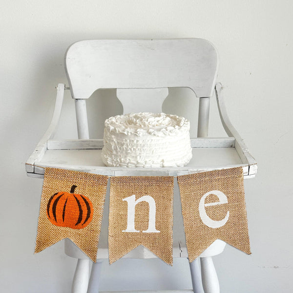Celebrate one with an orange pumpkin high chair banner. A rustic orange pumpkin as the O followed by an N E banner spelling out ONE. Perfect for a high chair banner or first birthday party backdrop.