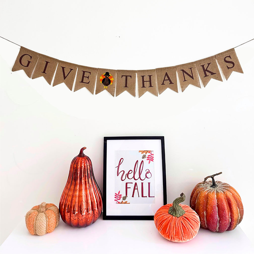 Give Thanks Thanksgiving burlap banner is a rustic design with the words Give Thanks written in brown font with a turkey image flag in between the two words. It&#39;s the perfect addition to your fall home decor.