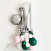 Girls golf party balloon tower featuring a silver number 1 balloon measuring 40in. paired with a round golf ball balloon measuring 18 in. sits on top of a pastel pink, green and white balloon tower this kit is the perfect addition to your golf party