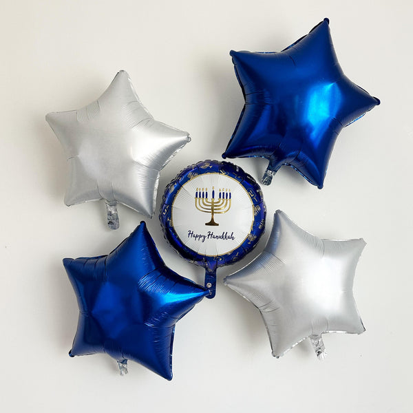 Blue & white Hanukkah balloon collection. Featuring a 17 in. round balloon that says Happy Hanukkah in the center below a Menorah surrounded by two blue star balloons and two white satin star balloons. Together there are 5 balloons in the collection.