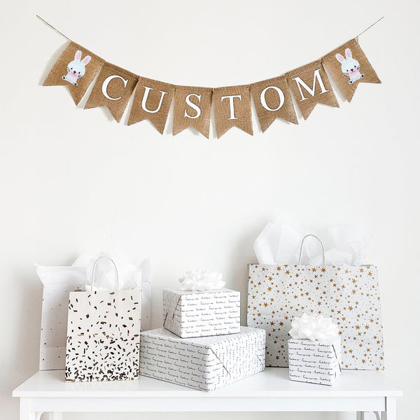 Custom burlap banner featuring two cute hand stenciled white bunnies on each end. This banner can be customized to say a name or any quote or saying that fits in with your decor. It&#39;s perfect for a baby shower, nursery decor or some seasonal decorations.