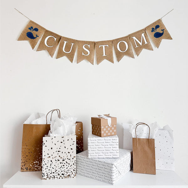 This ocean themed custom banner comes with two hand stenciled navy blue whales. In between the two image flags is a customizable banner, in white letters on fishtail burlap banners. You can add a name, date, or personalized phrase or saying to customize your party and take your theme to the next level.