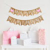 A burlap banner made from 4.5 by 6.5 inch fishtail shaped flags. The top string says HAPPY in white capital letters with a pink printed watercolor pumpkin on each end. The bottom string says BIRTHDAY in white capital letters.