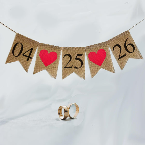 This burlap banner has a customizable date banner. Add your custom date in black or white numbers over fishtail flags. Between each number in the date you have your choice of red hearts or white hearts.