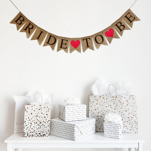 Celebrate the bride to be with this fishtail burlap banner. With black letters that spell out the word &quot;Bride to Be&quot; with red hearts between each word, it&#39;s the perfect addition to an engagement party, bridal shower or wedding celebration.