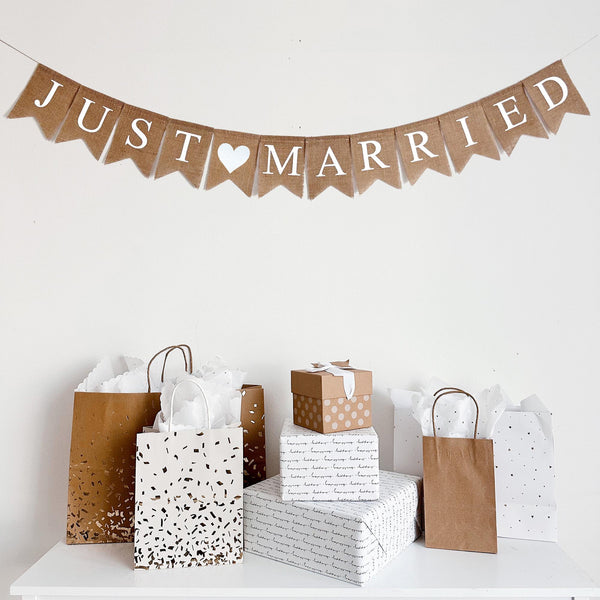 This Just Married burlap banner contains white letters on burlap fishtail flags. Between the two words there is a hand stenciled white heart adding a touch of romance to your event.