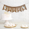 One first birthday burlap banner. This banner has 2 adorable hand stenciled white bunnies wearing a blue ribbon. The word one is written on the flags in white lowercase font.