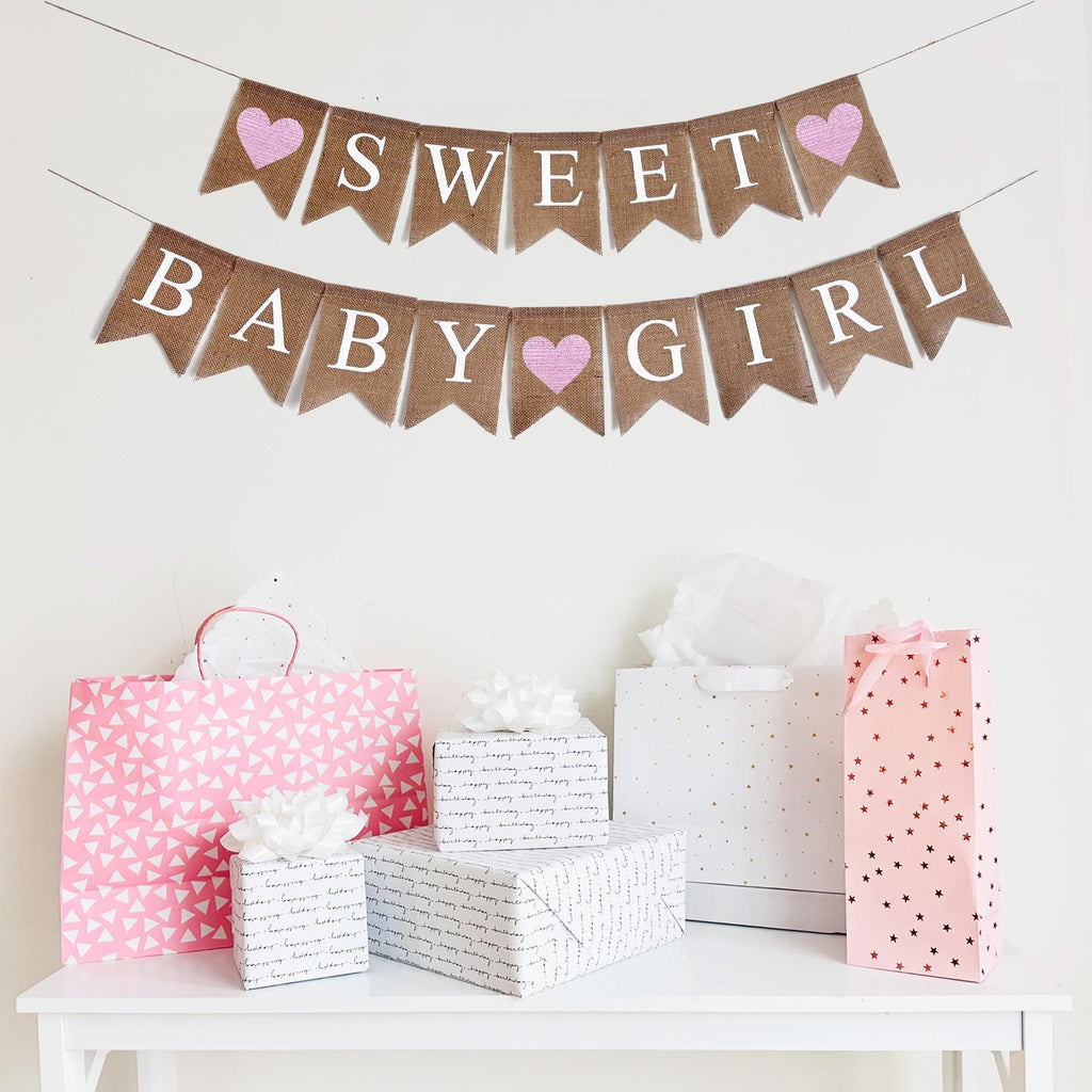 A Sweet Baby Girl burlap banner strung on one string. Hand painted pink hearts on each end of the word SWEET on the top layer, and then between the words BABY and GIRL on the second line.