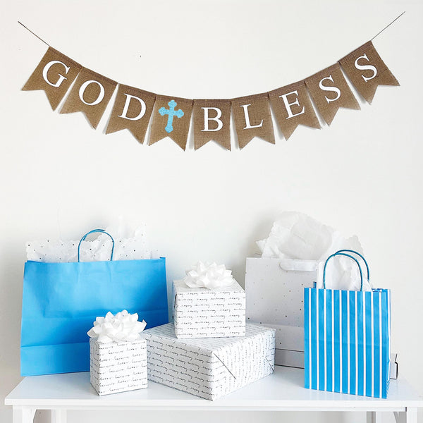 This burlap banner spells out the words God Bless in white font with a blue hand stenciled cross separating the two words. This banner is also available with a pink cross or a white cross, to easily coordinate with any party or color scheme.