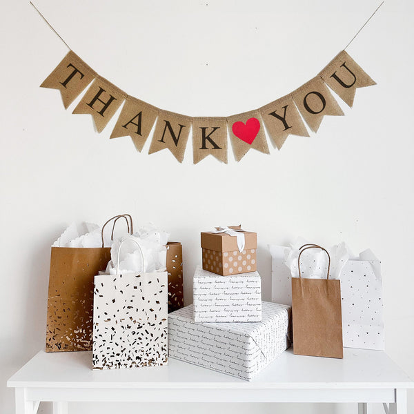 This rustic Thank You banner is written out in black lettering with a red heart between the two words. Perfect way to show your gratitude at a wedding, graduation party, or any other celebration.