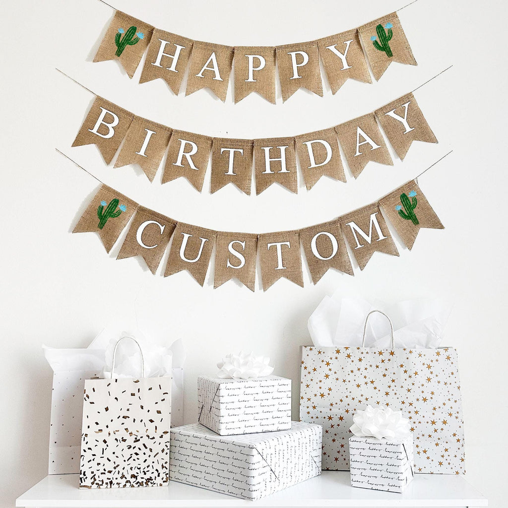 A happy birthday burlap banner strung on two or three strings. The top row reads &quot;HAPPY&quot; with a hand painted green cactus with blue flowers on each end of the word. The second line reads &quot;BIRTHDAY&quot;.  The third optional line give your the choice to add a personalization to your banner.  The personalized line also has a cactus with blue flowers on either end of the wording of your choice.