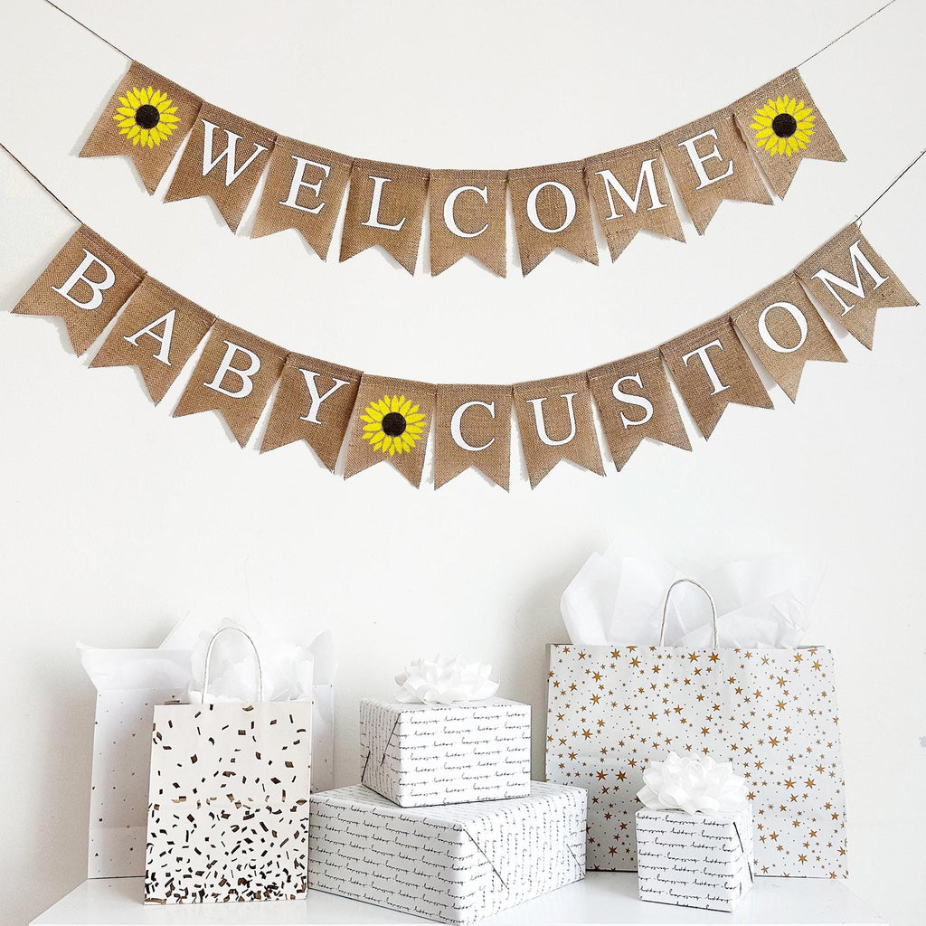 This burlap banner reads Welcome Baby with sunflower flags on either side of the word welcome. The sunflowers are hand painted in a vibrant yellow with a dark brown center making them the perfect addition to your celebration.