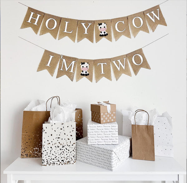 Holy Cow I&#39;m Two burlap banner. This banner features two layers. The top layer says Holy Cow with a hand stenciled baby cow image between the two words. The second line reads I&#39;m Two with another baby cow in between the two words.